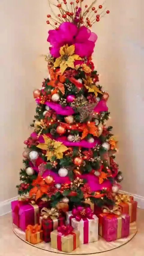 Pink gold and orange decorated Christmas tree with wrapped gifts